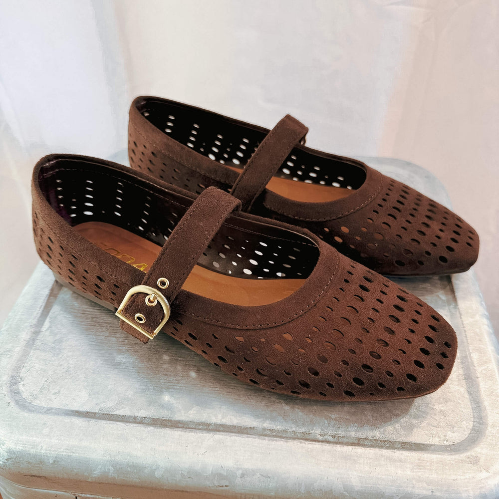 A pair of dark brown perforated suede Mary Jane flats with a gold-tone buckle strap